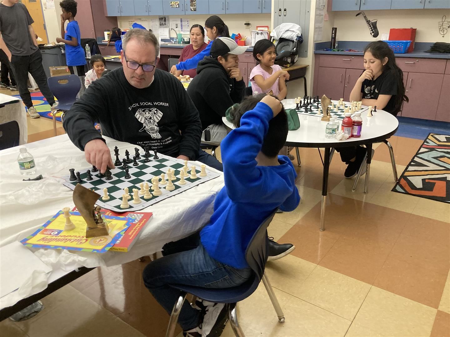A chess coach plays a game with a student