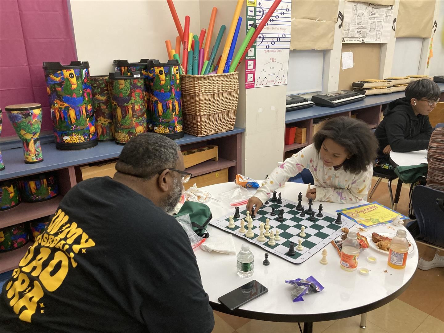 A girls plays chess with her father