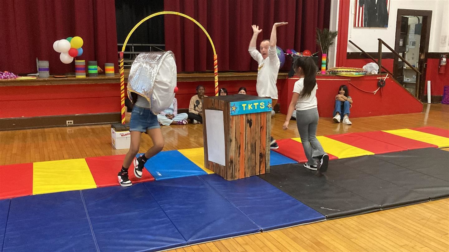 Two students chase a man, one dressed as a pie.