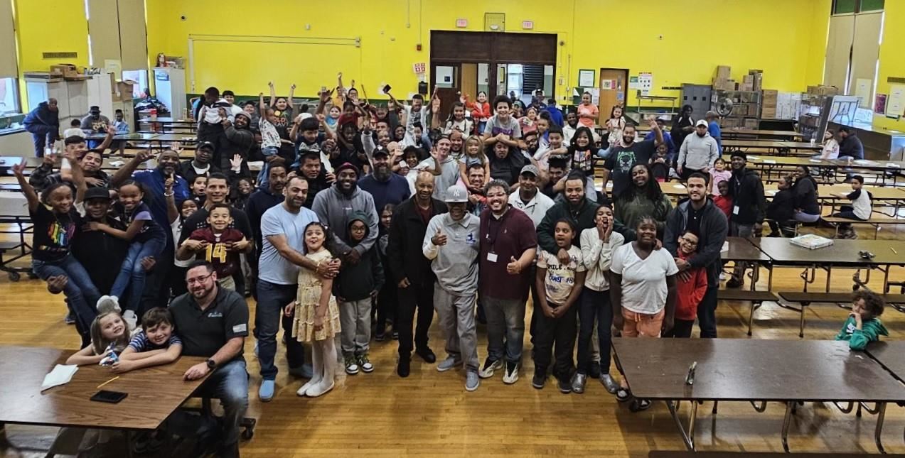  Attendees of Donuts with Dad pose together for a large group photo in Krieger's cafeteria