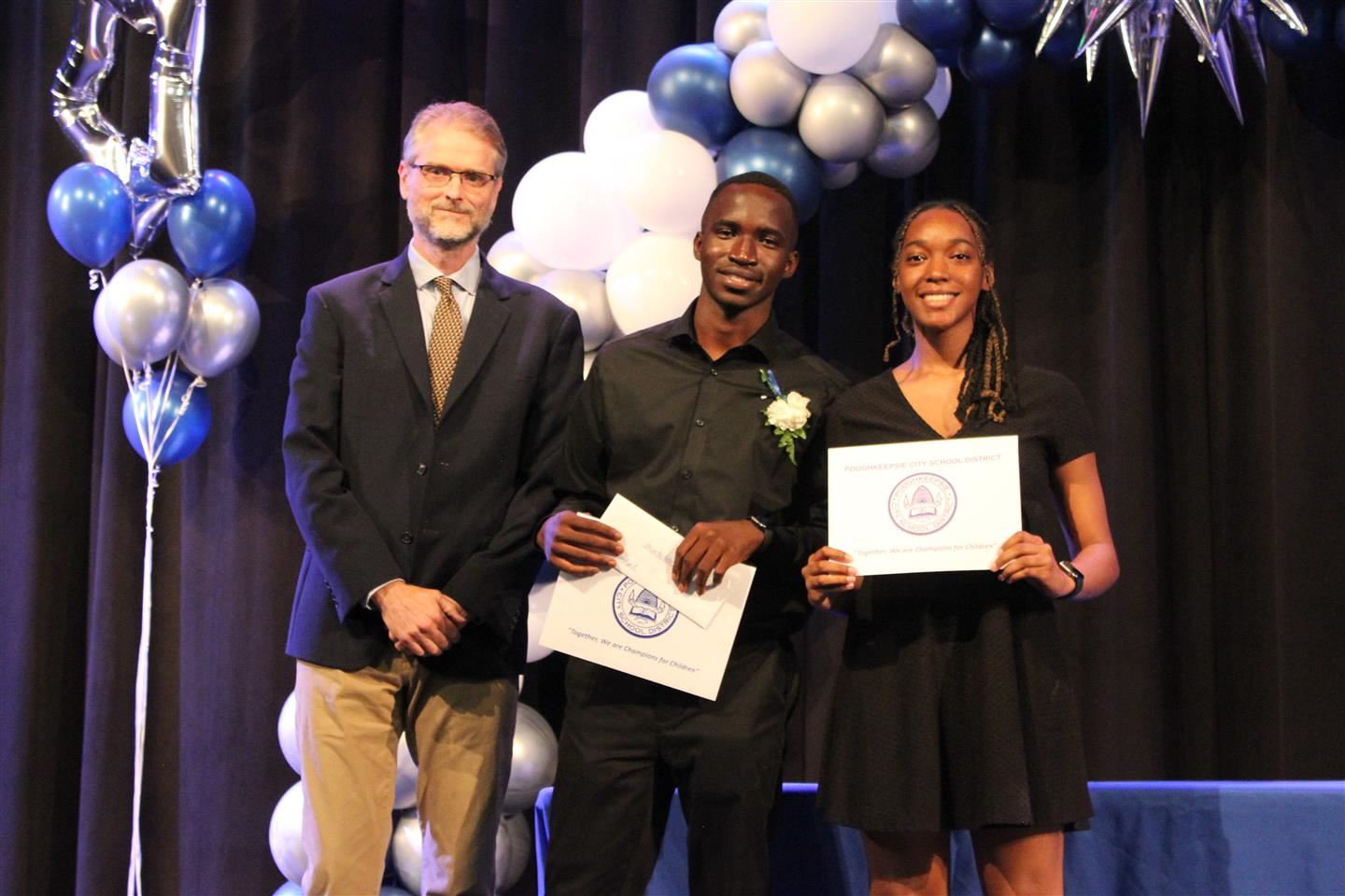  Three people pose together with certificates