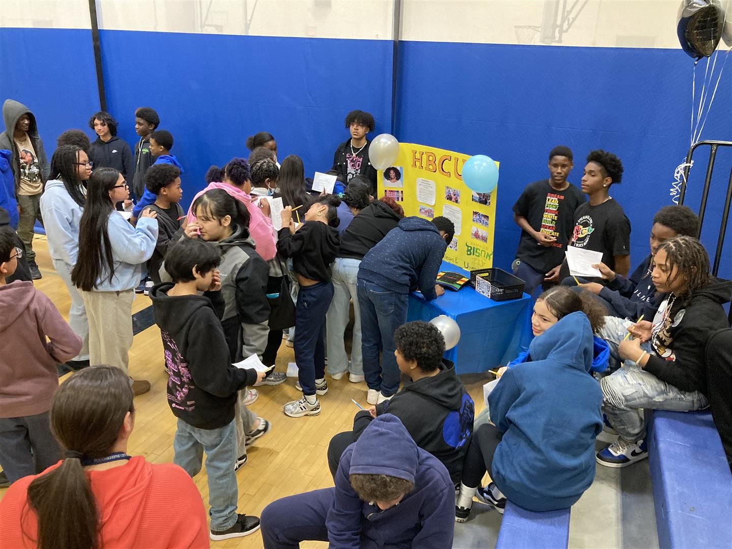 Students gather around a table with three students discussing HBCUs.