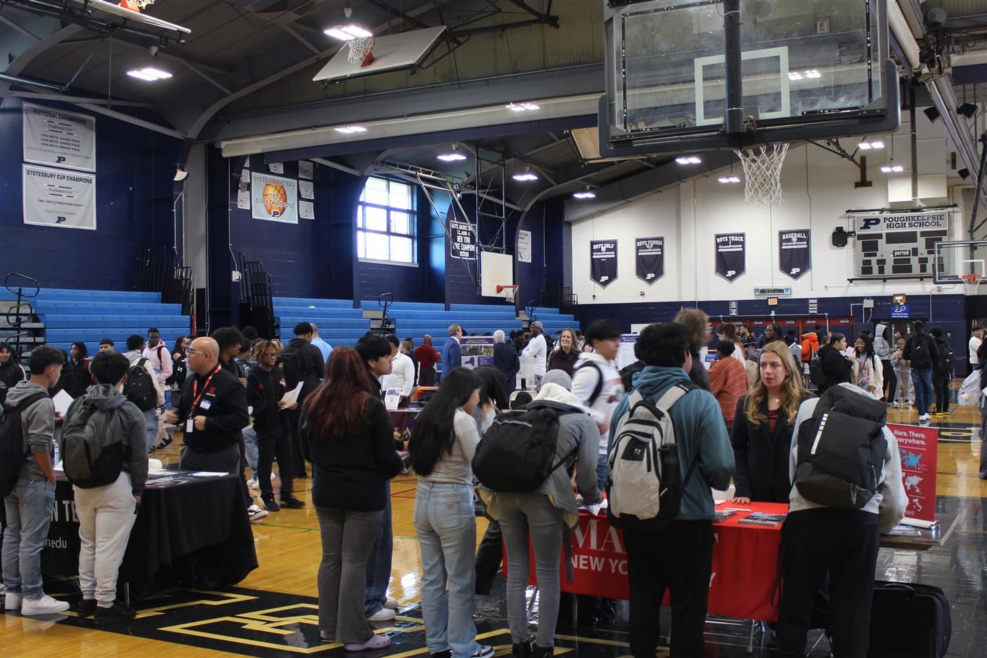 crowds of students visit with college reps at tables
