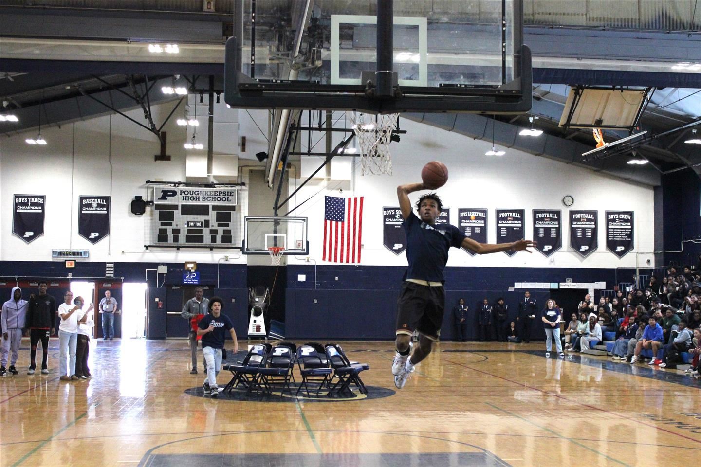  A student dunks a basketball as others look on.