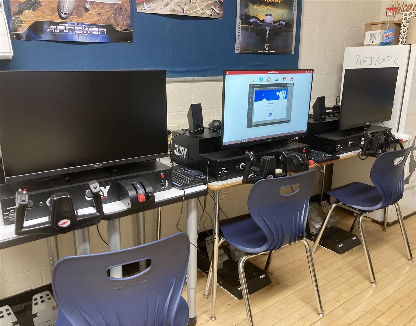 Three flight simulators sit in a classroom