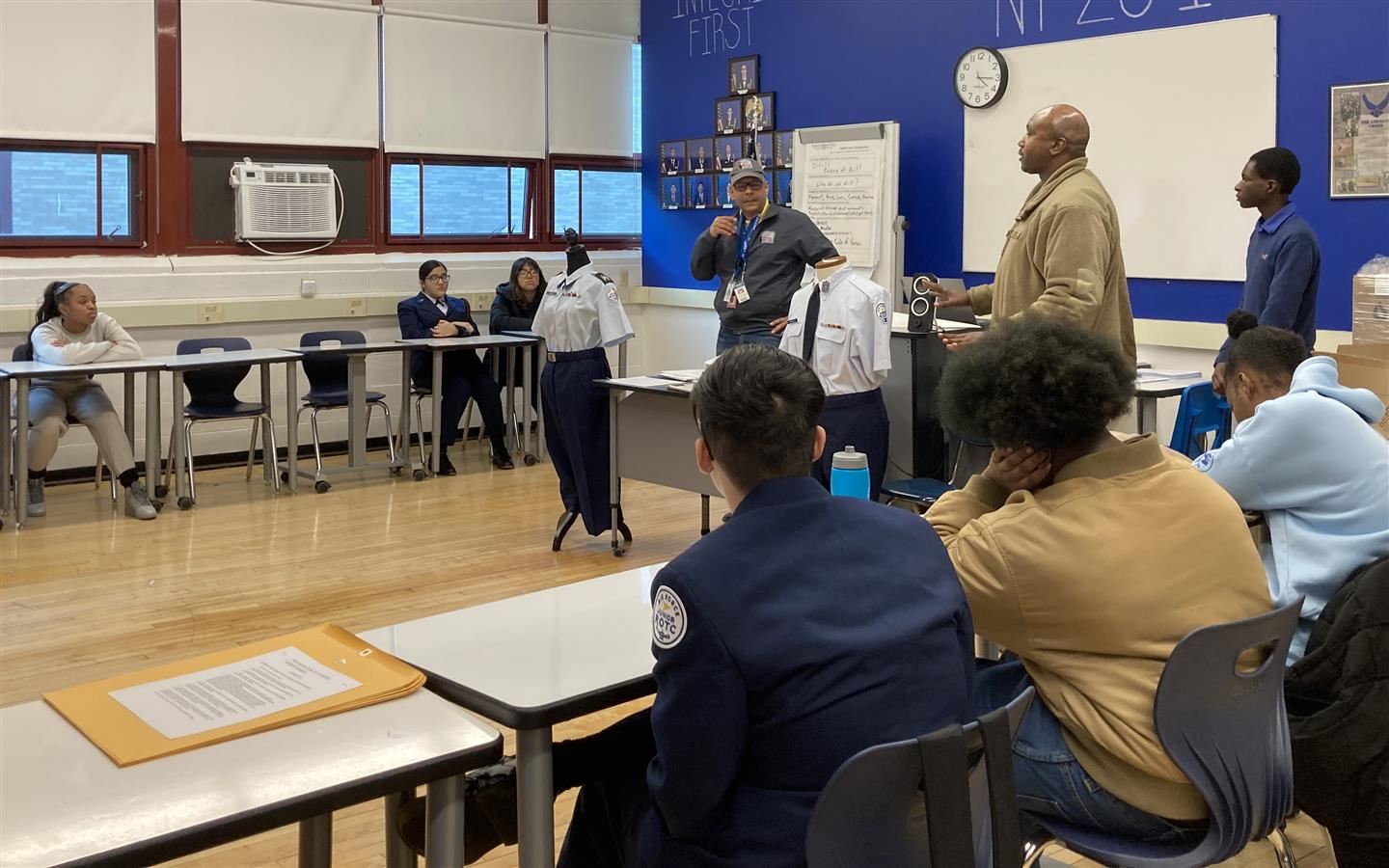 Carlos Rodriguez, Master Sgt. Malachi Carmichael & Cadet 2nd Lt. Milton Kamura speak in a classroom