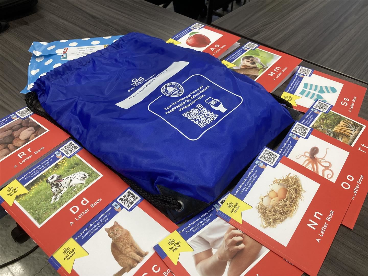  Decodables books and the personalized blue bag each student will receive is pictured on a desk.