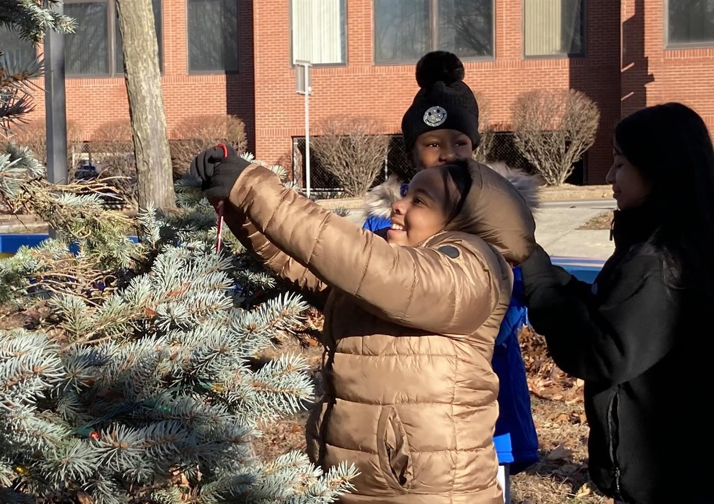 Timia Evans hangs an ornament on the tree.