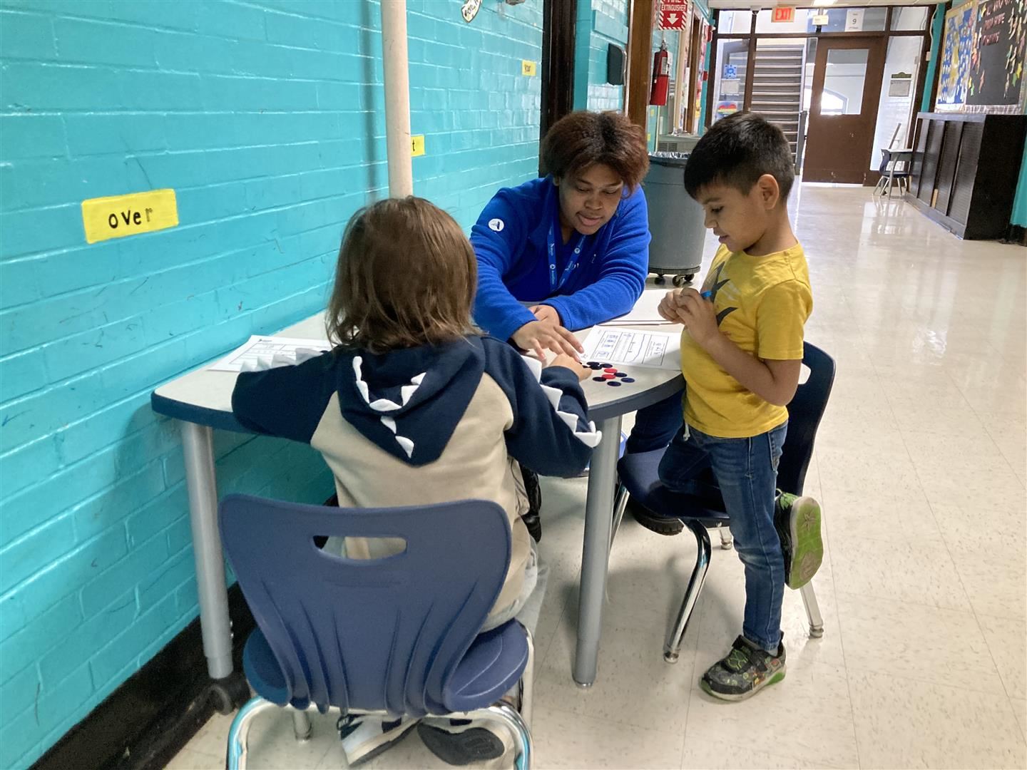  A tutor and two children sitting at a table