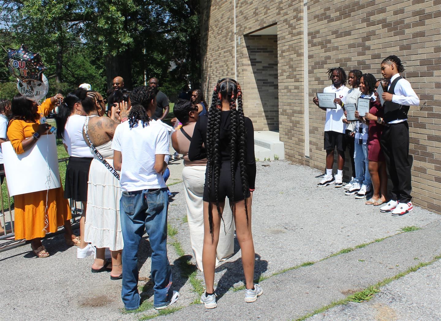 A group of Poughkeepsie Middle School students pose for photos outside the school after the moving up ceremony