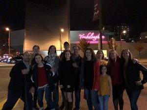 Adults and students on sidewalk at nighttime