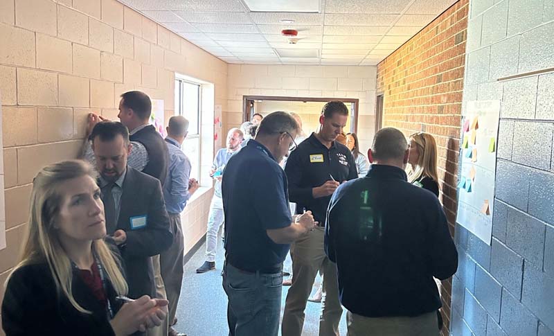 People looking at a billboard in a hallway