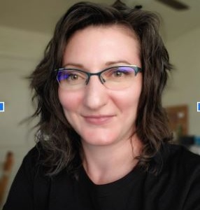 Ms. Richardson teacher for SDPA. Brown hair and wearing glasses. Posing to take picture.