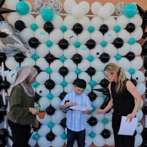 SDPA student and two teachers taking a picture to celebrate 5th promotion.