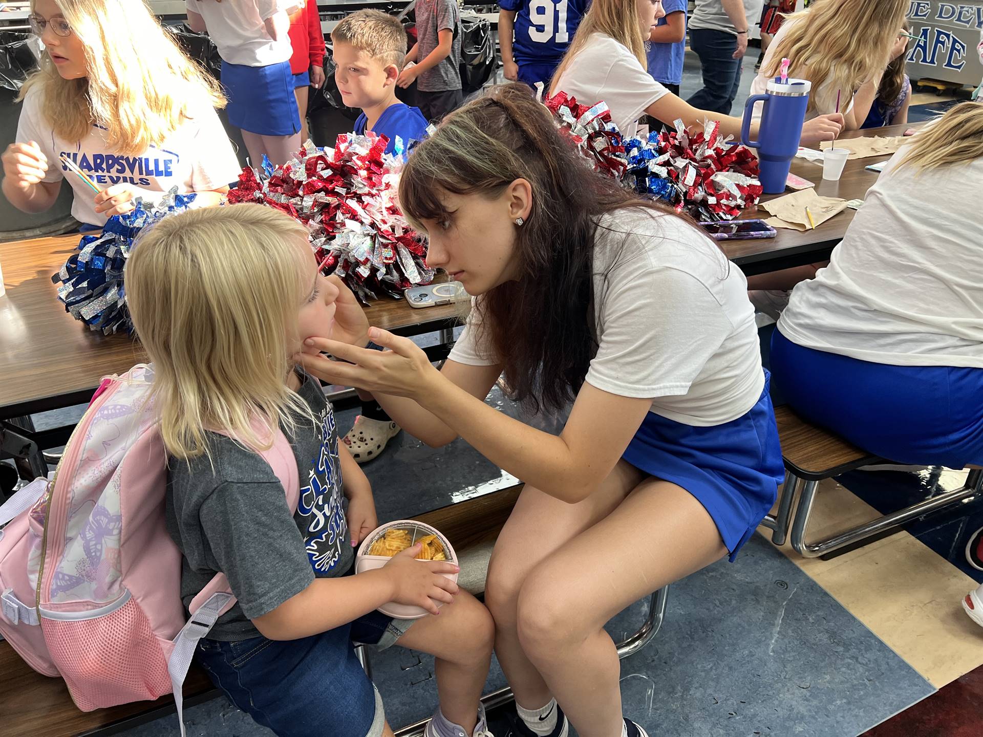 Cheerleaders painting faces for SAES students