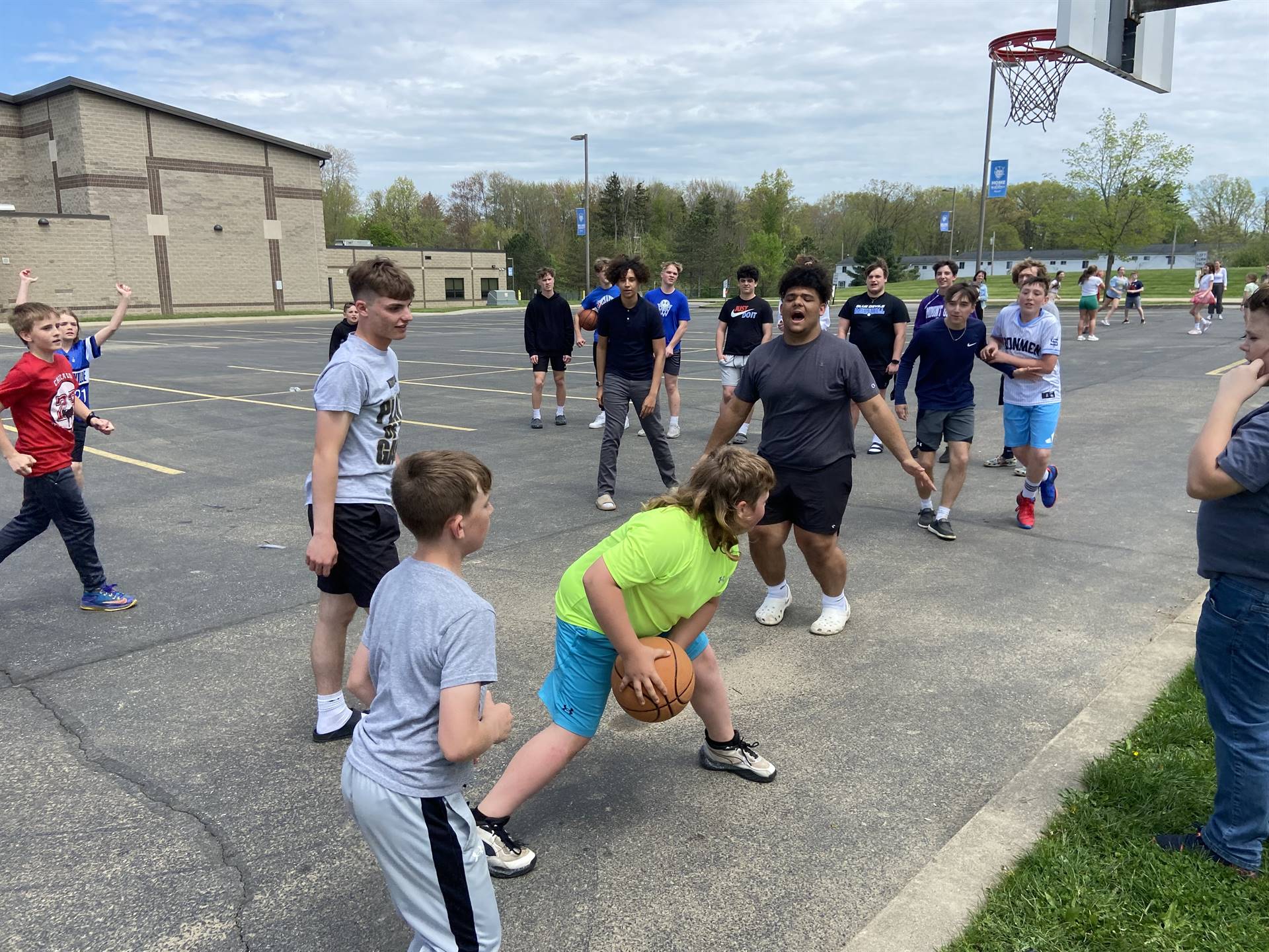 Sharpsville High School students playing a game of basketball with younger students