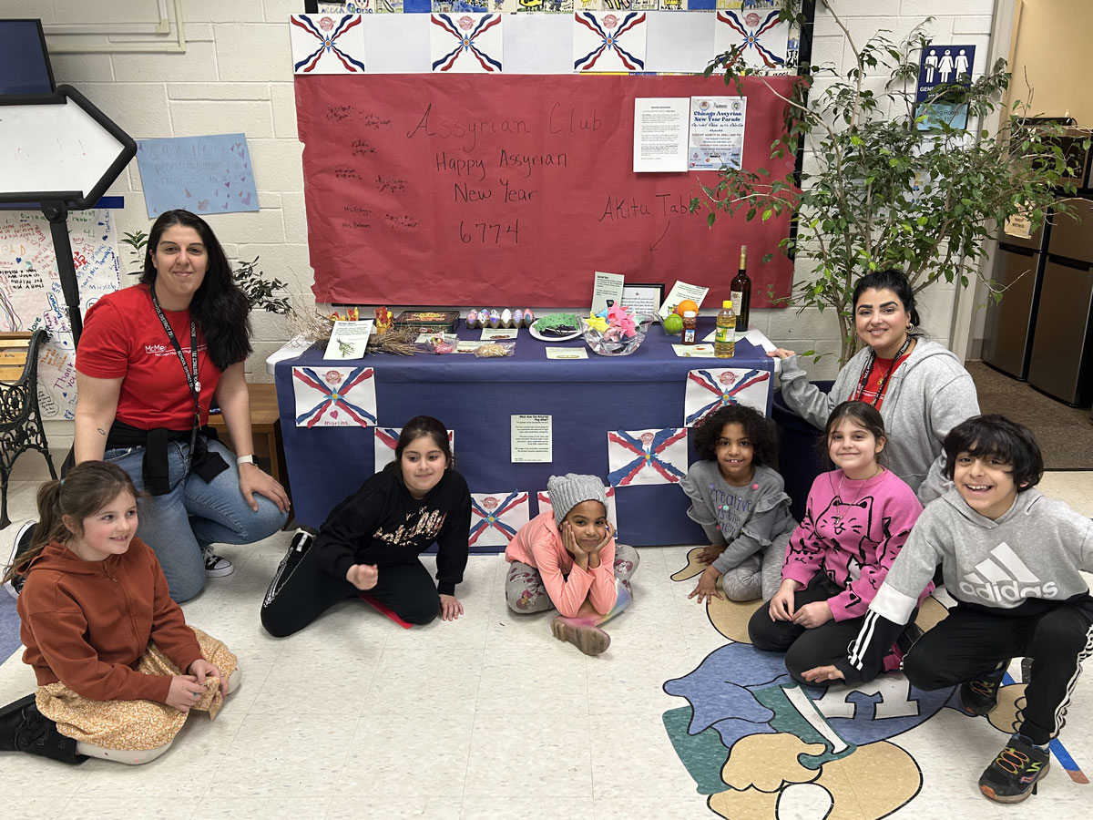Photo of students and teachers in front of the Akitu table