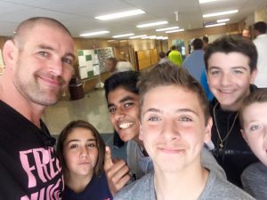 group of middle school students pose with the presenter