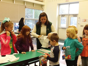 elementary students put together supplies for the troops in their classroom