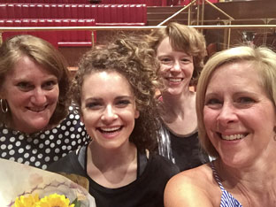 close up of four women's faces smiling