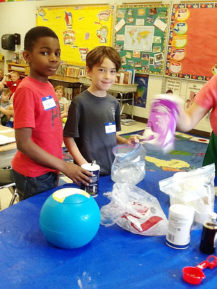 two young boys make homemade ice cream in class