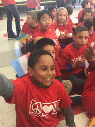 children sitting on the floor wearing their red T shirts