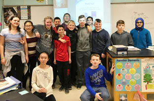 middle school students gather in classroom for a group photo