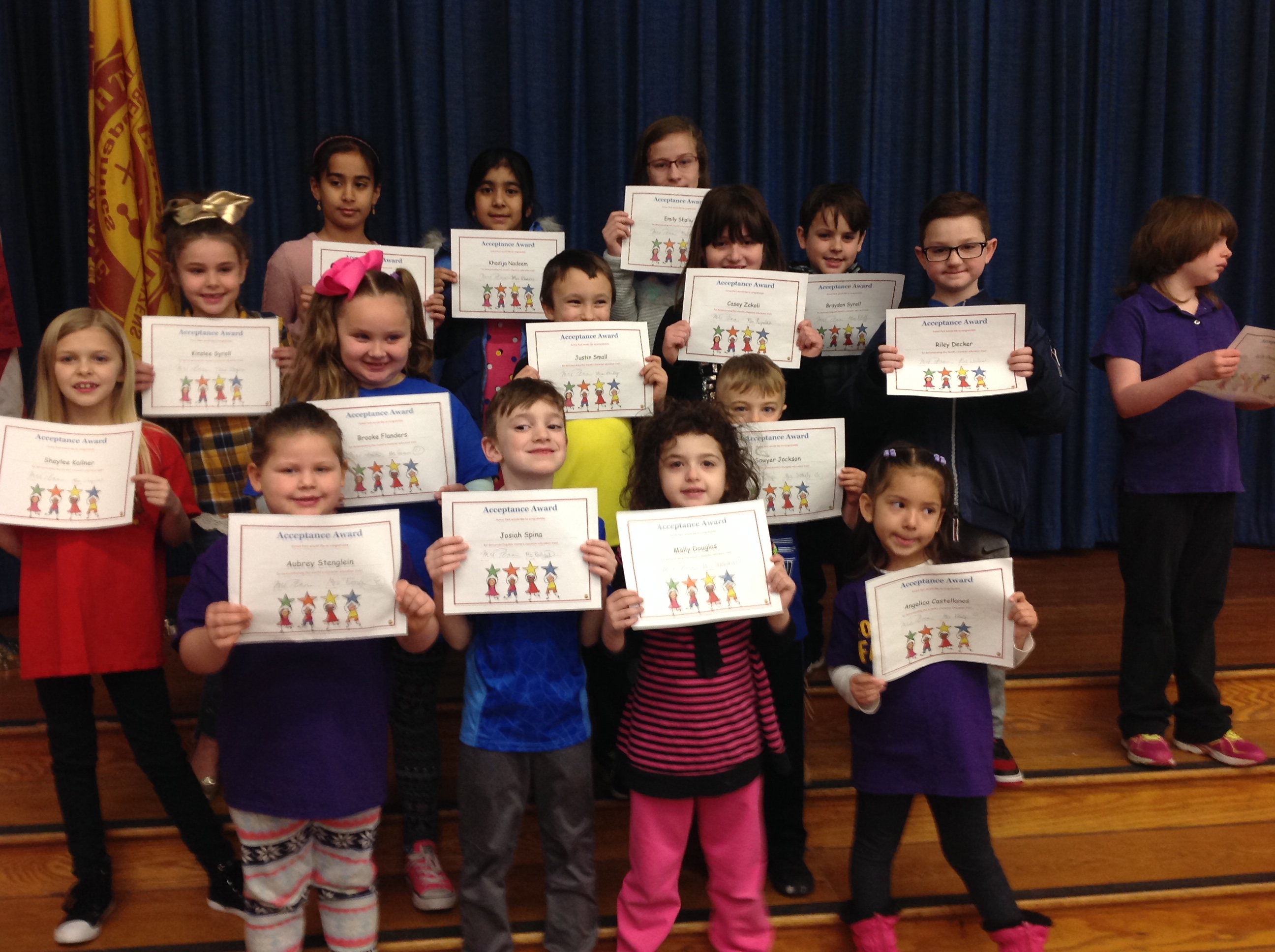 students hold up their award certificates