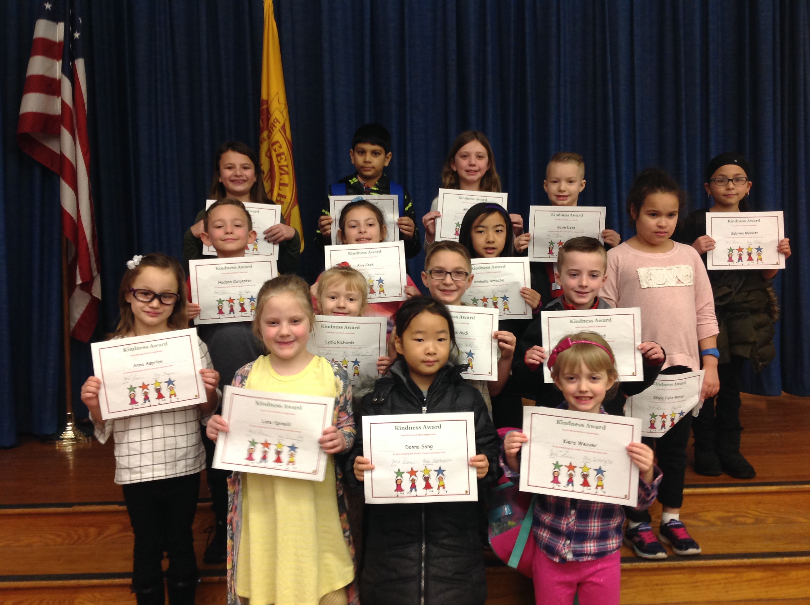 group of students hold up their award certificates