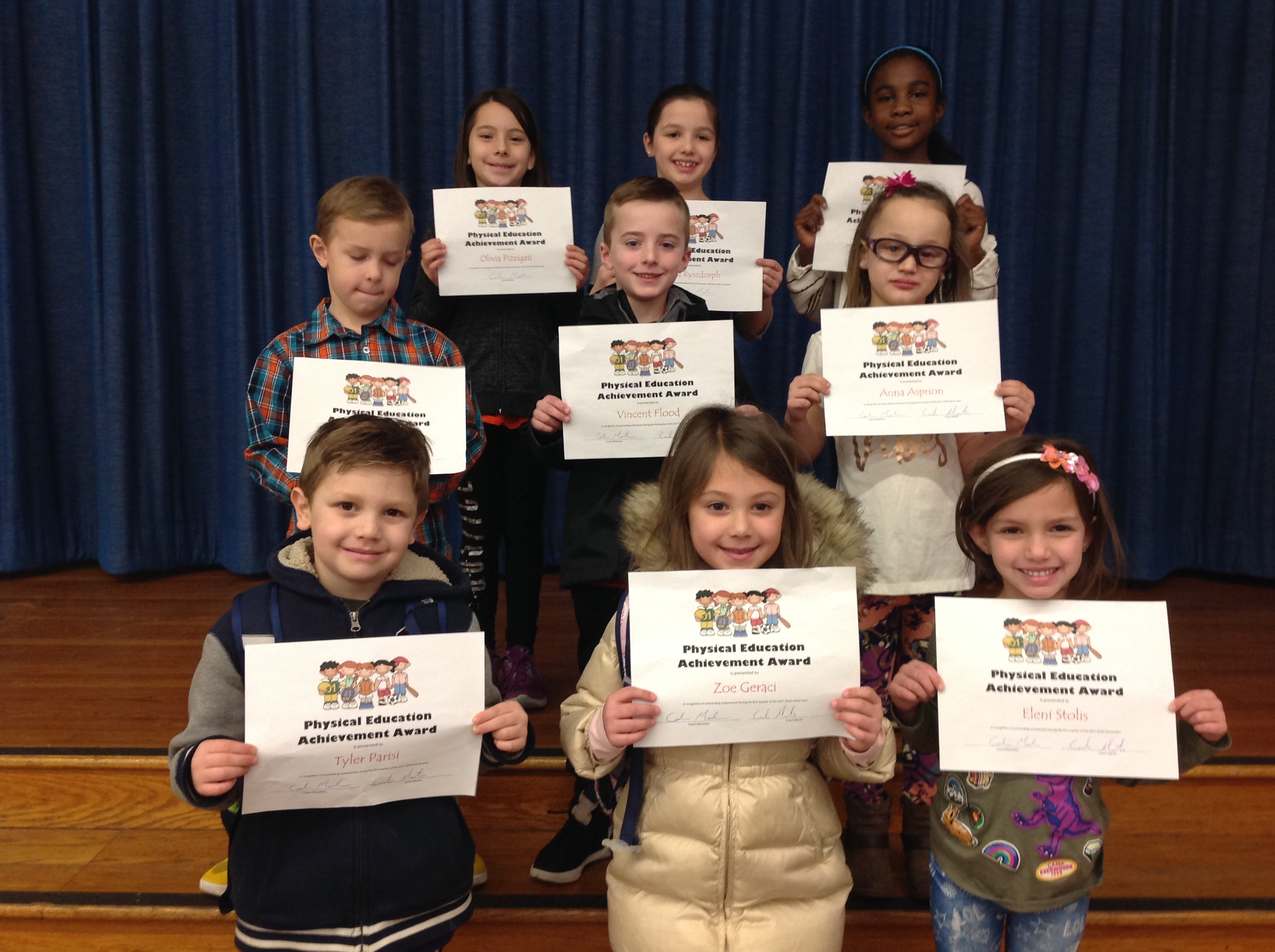 students hold up their award certificates