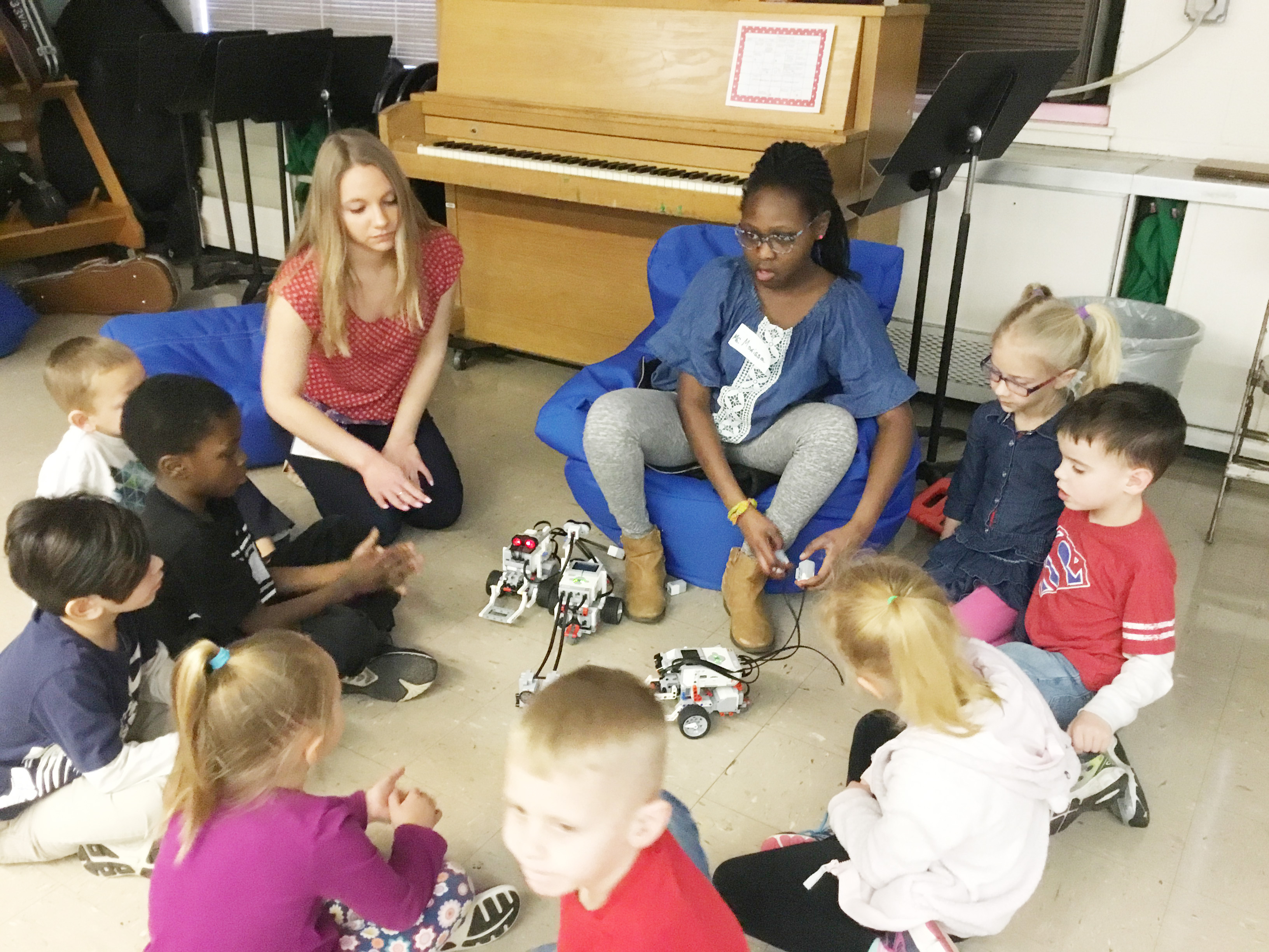 students work with robots on the classroom floor in a large group