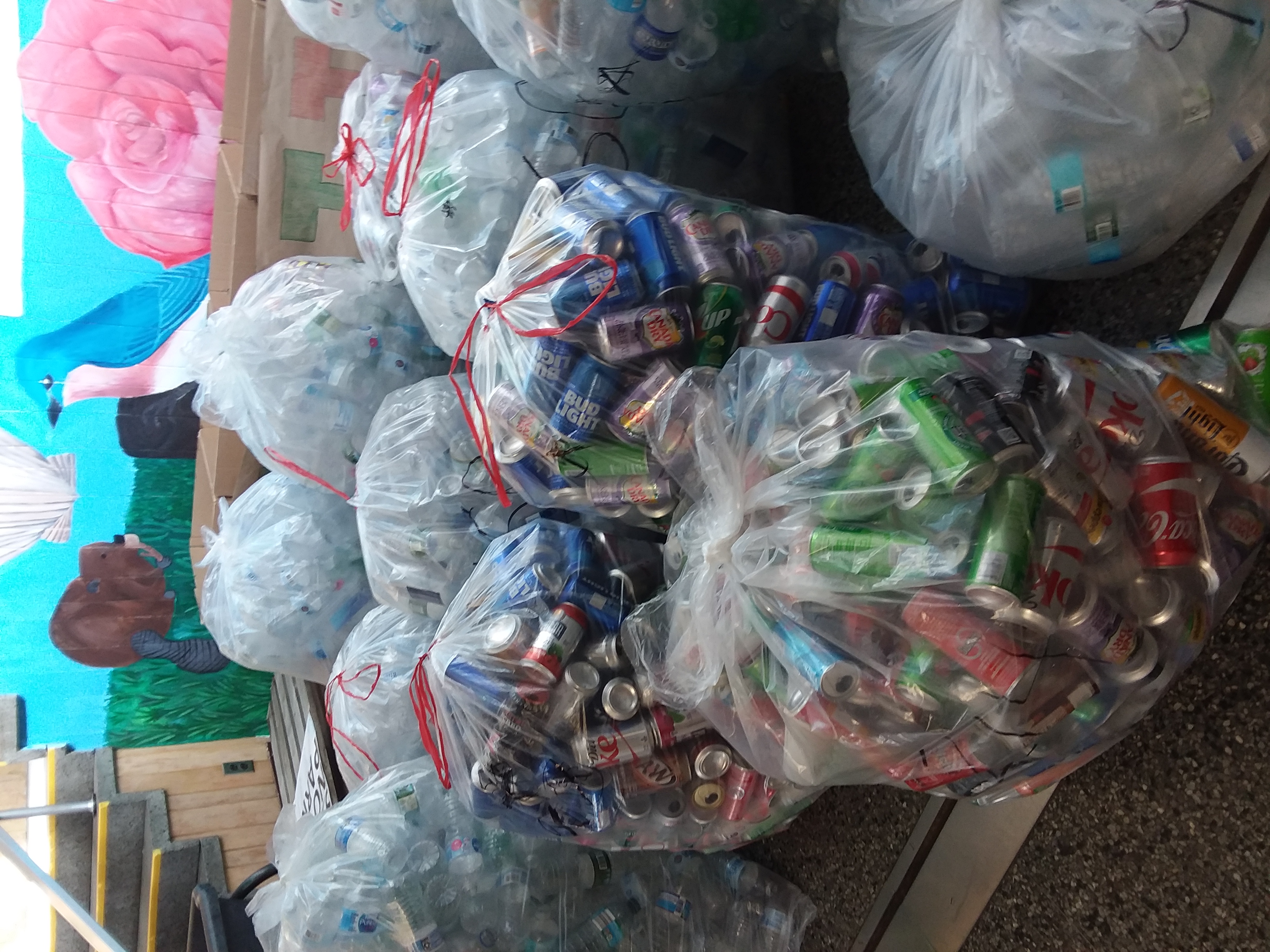 many plastic bag full of bottles stacked