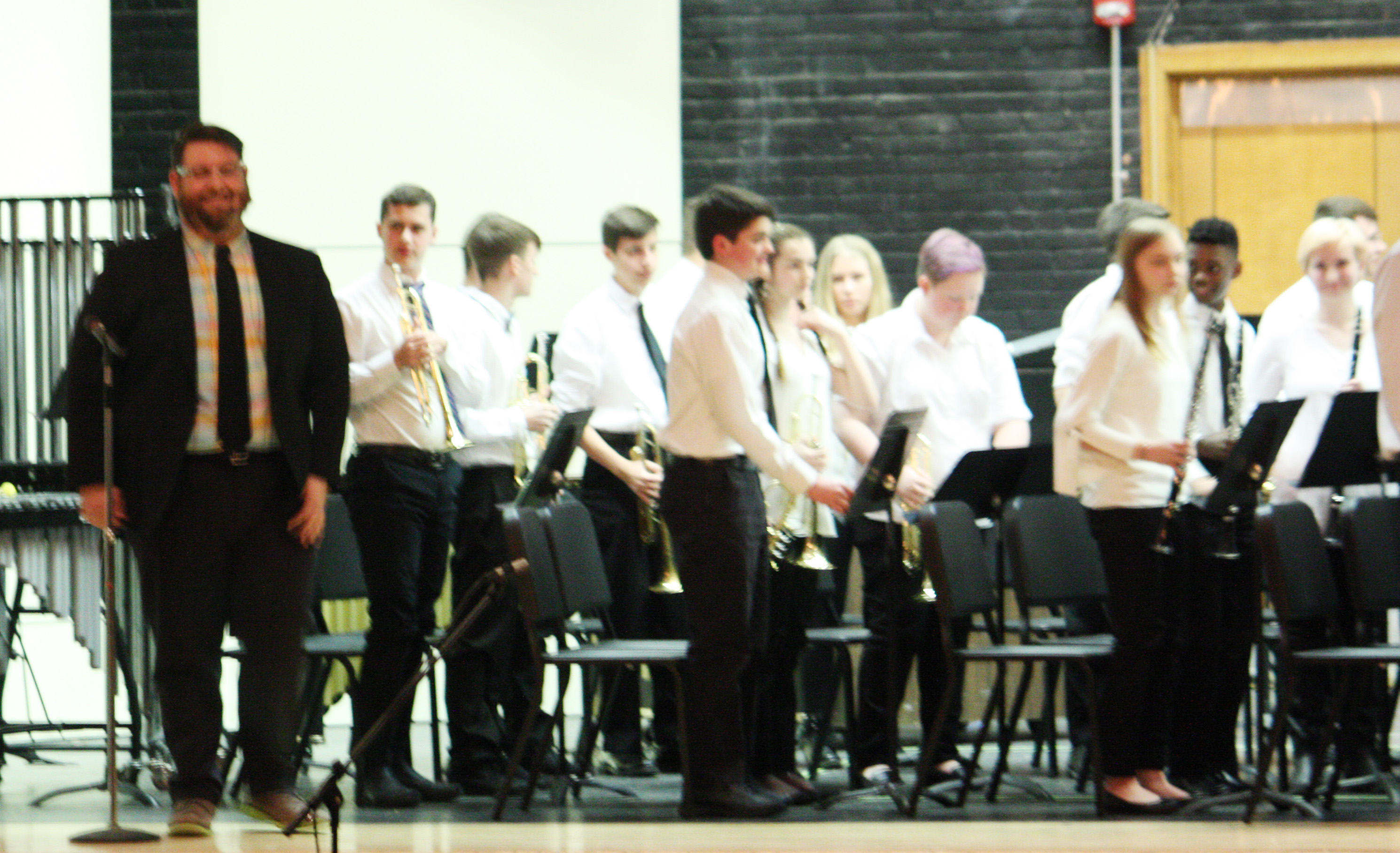 high school string orchestra performs on stage