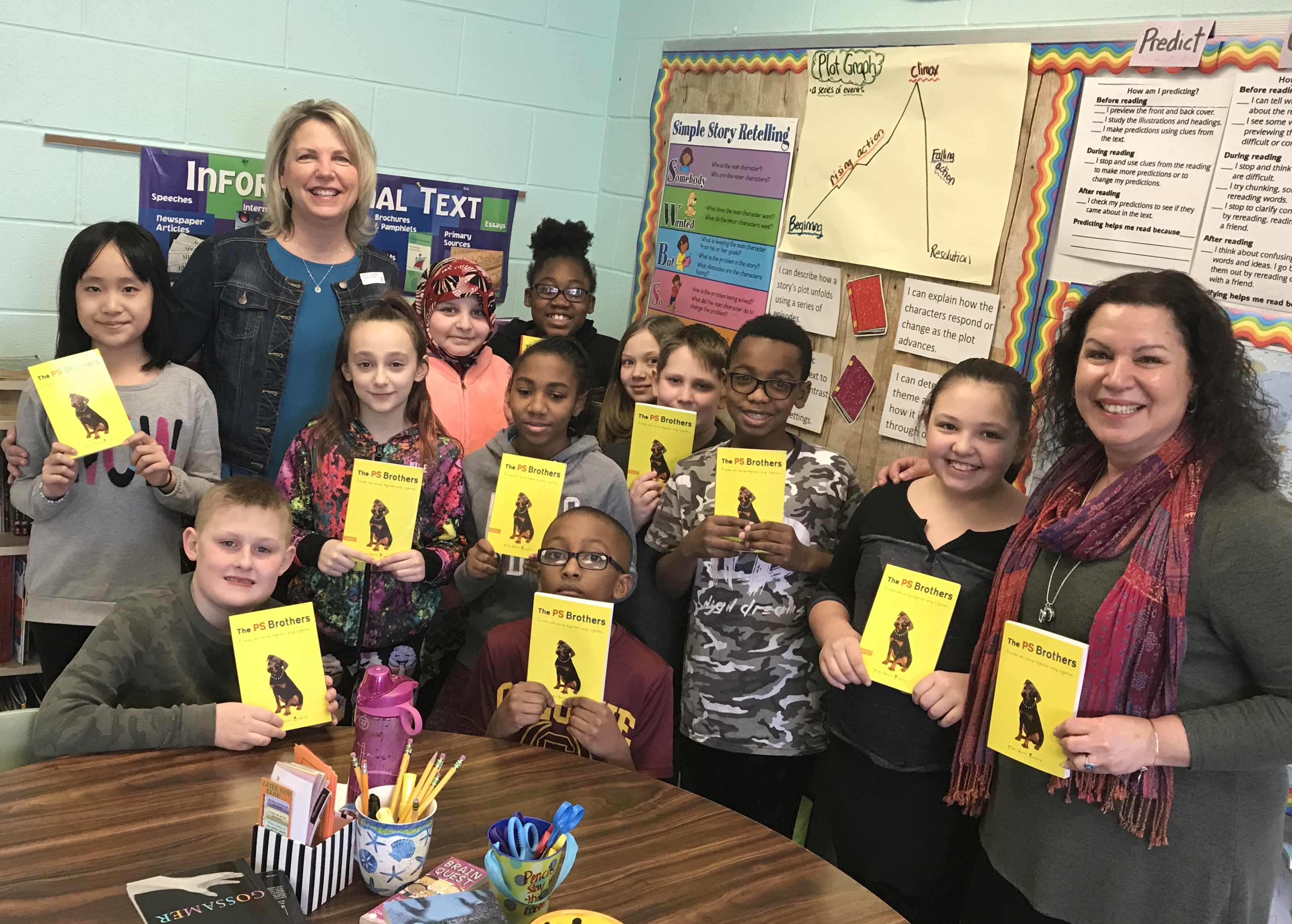 5th graders stand with author showing off her book