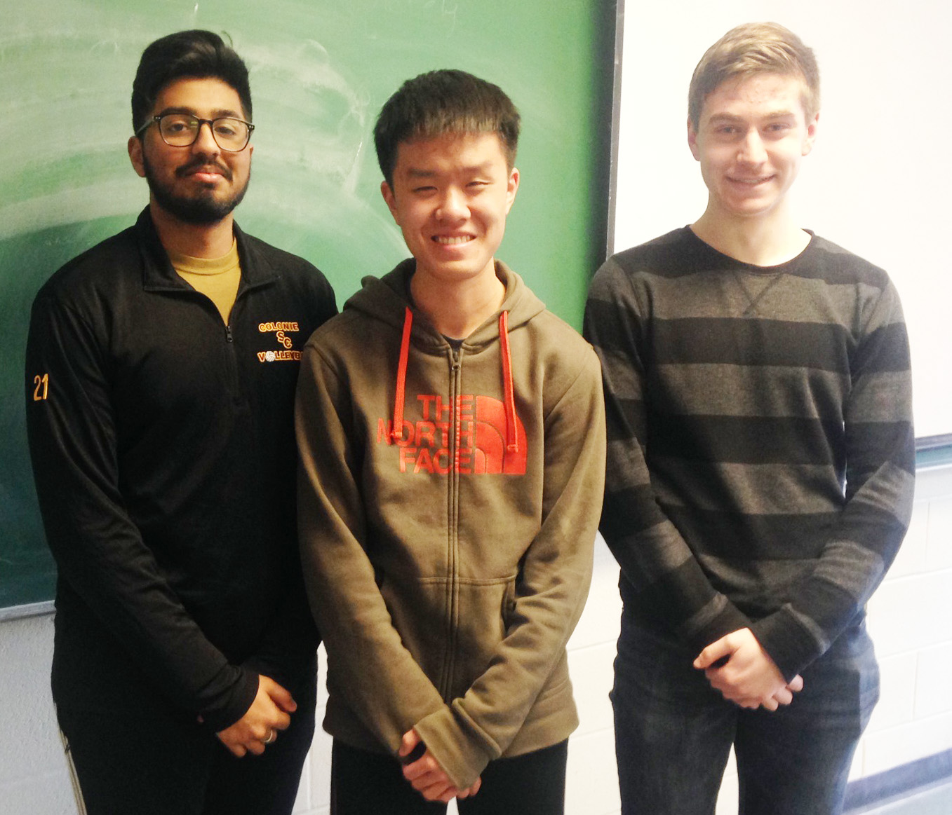 three high school students stand together