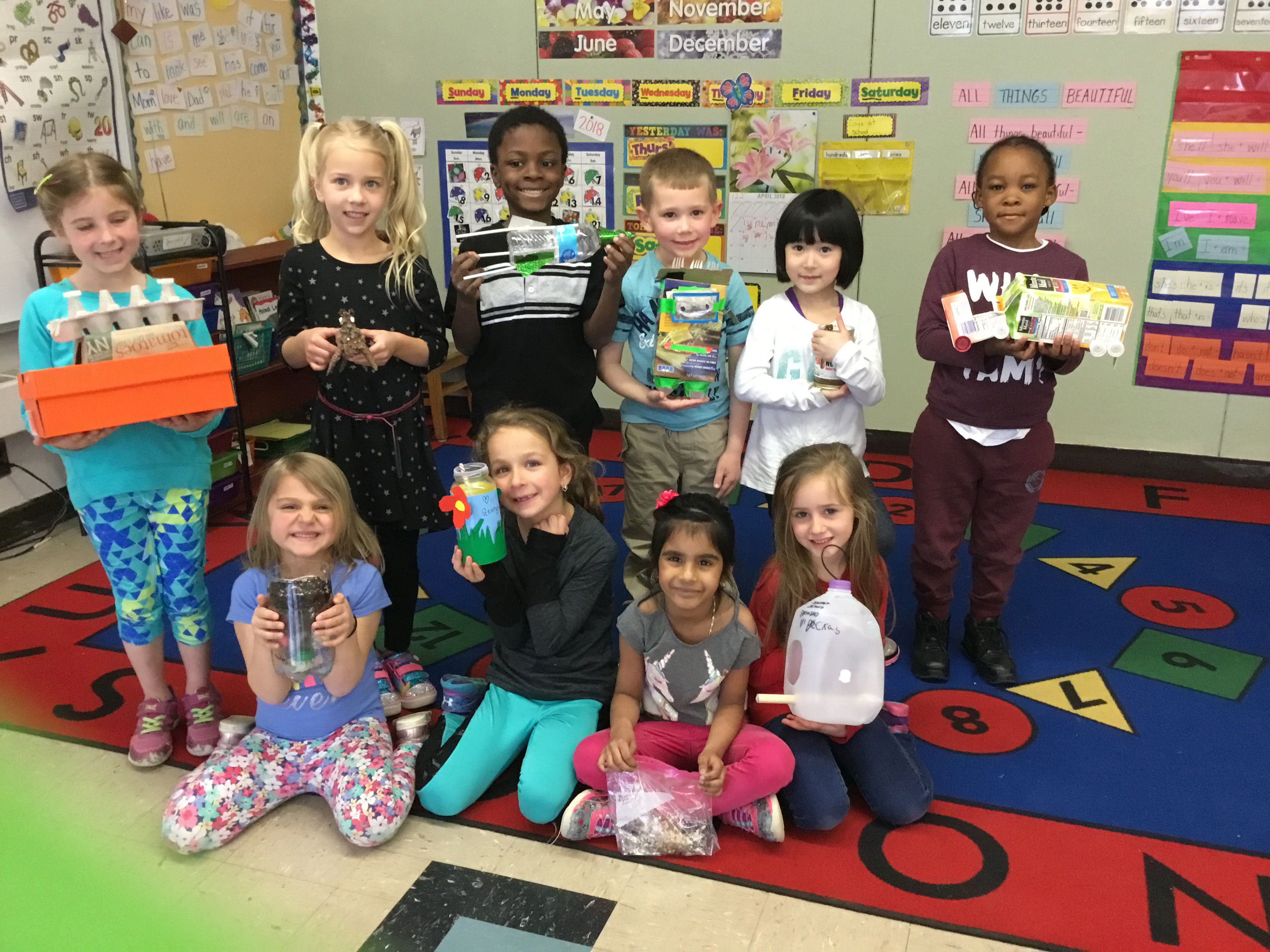 children show their recycled items