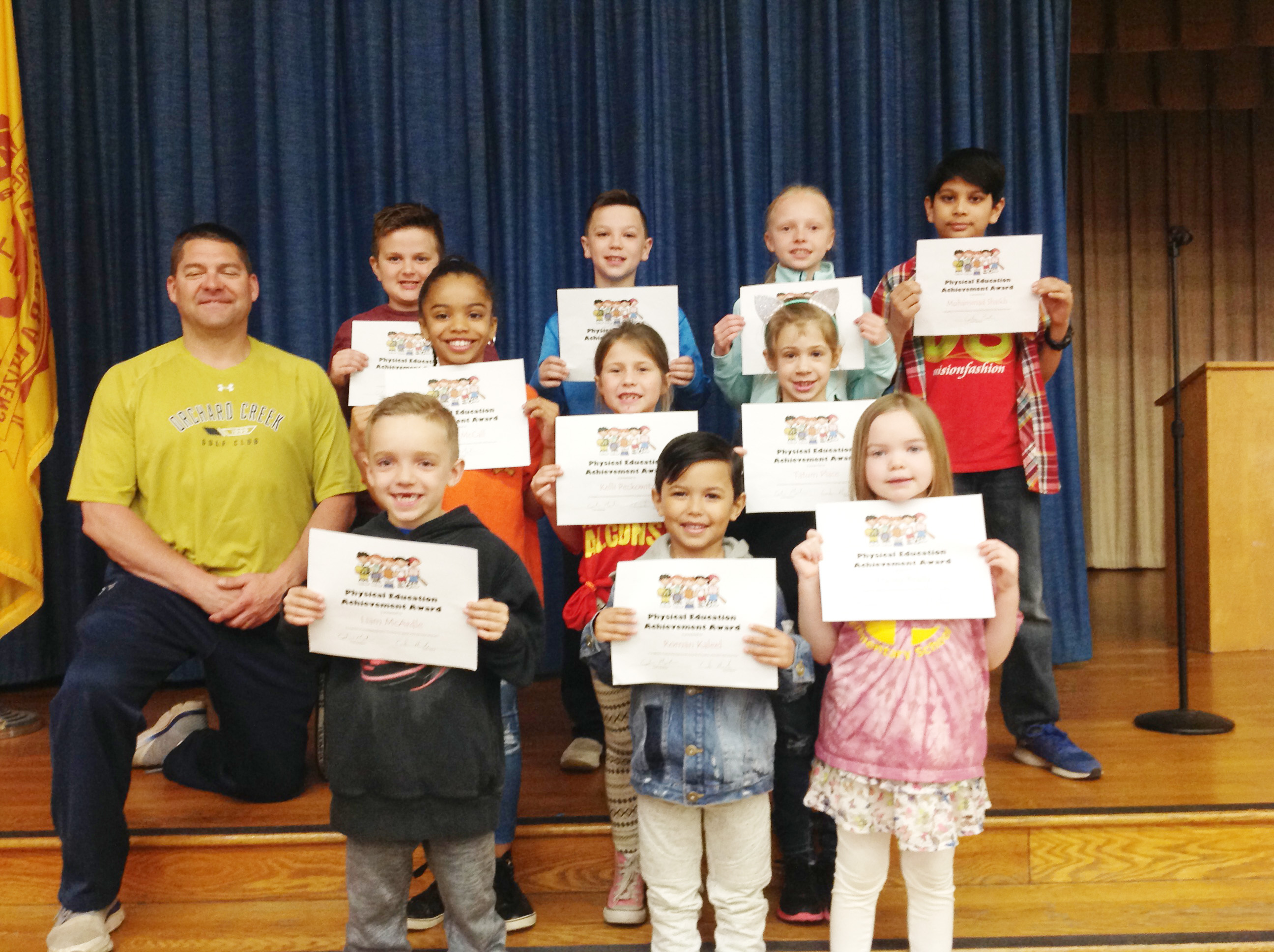 group of student hold up their award certificates