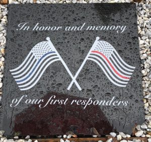 stone honoring first responders featuring 2 American flags