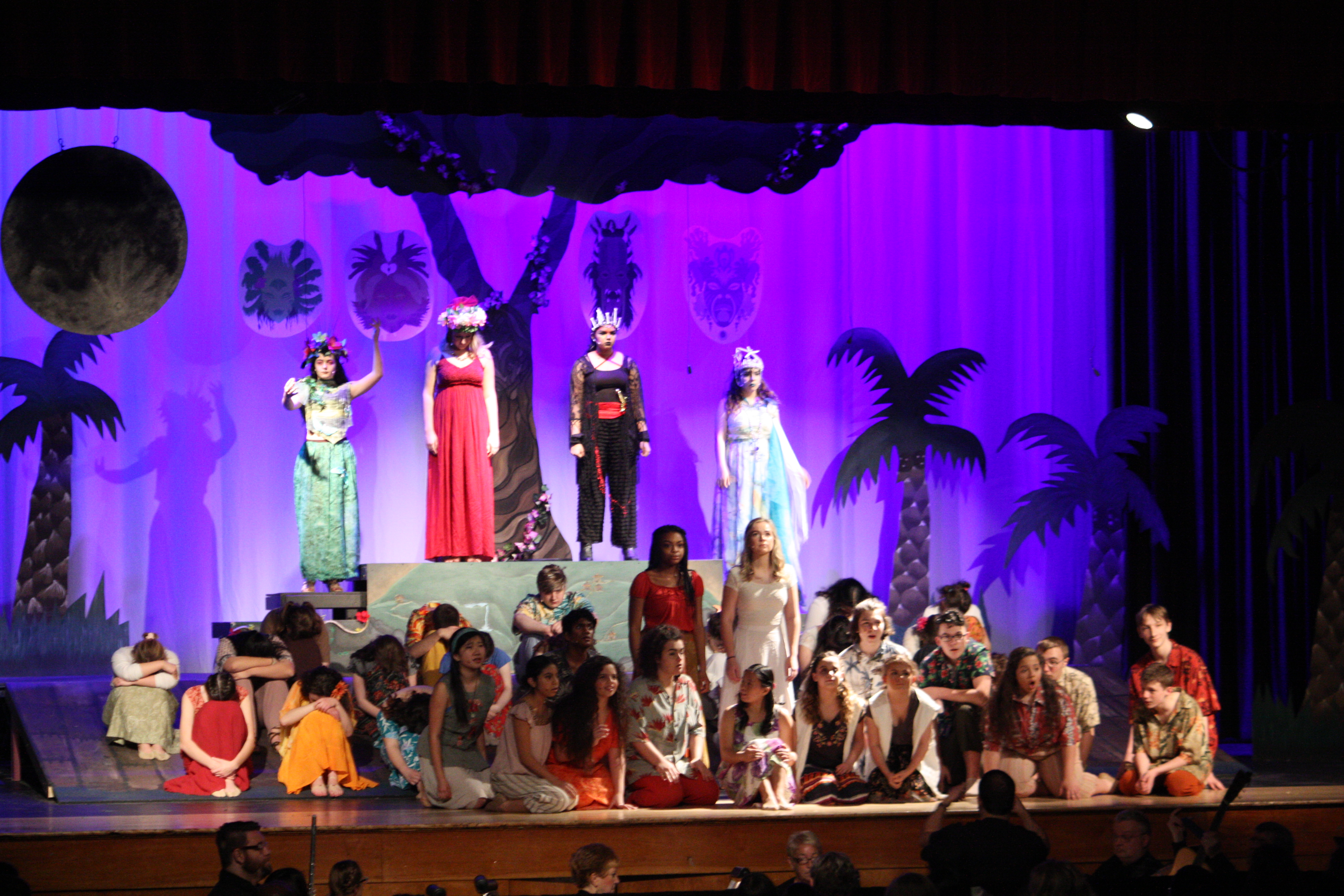 high school actors on stage dressed in island attire