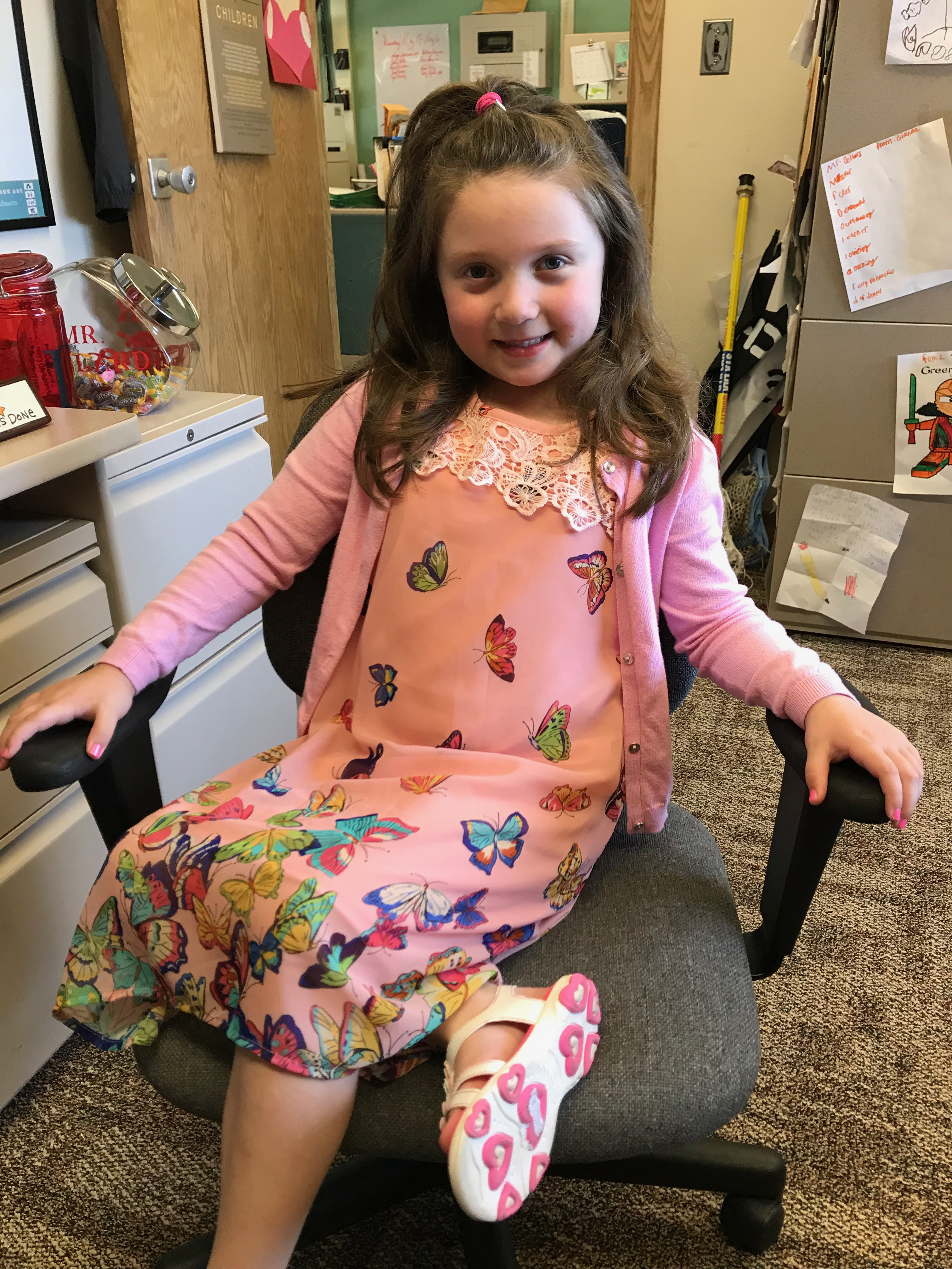 elementary kid sits in the principal's chair