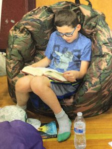 boy reading a book in a bean bag chair