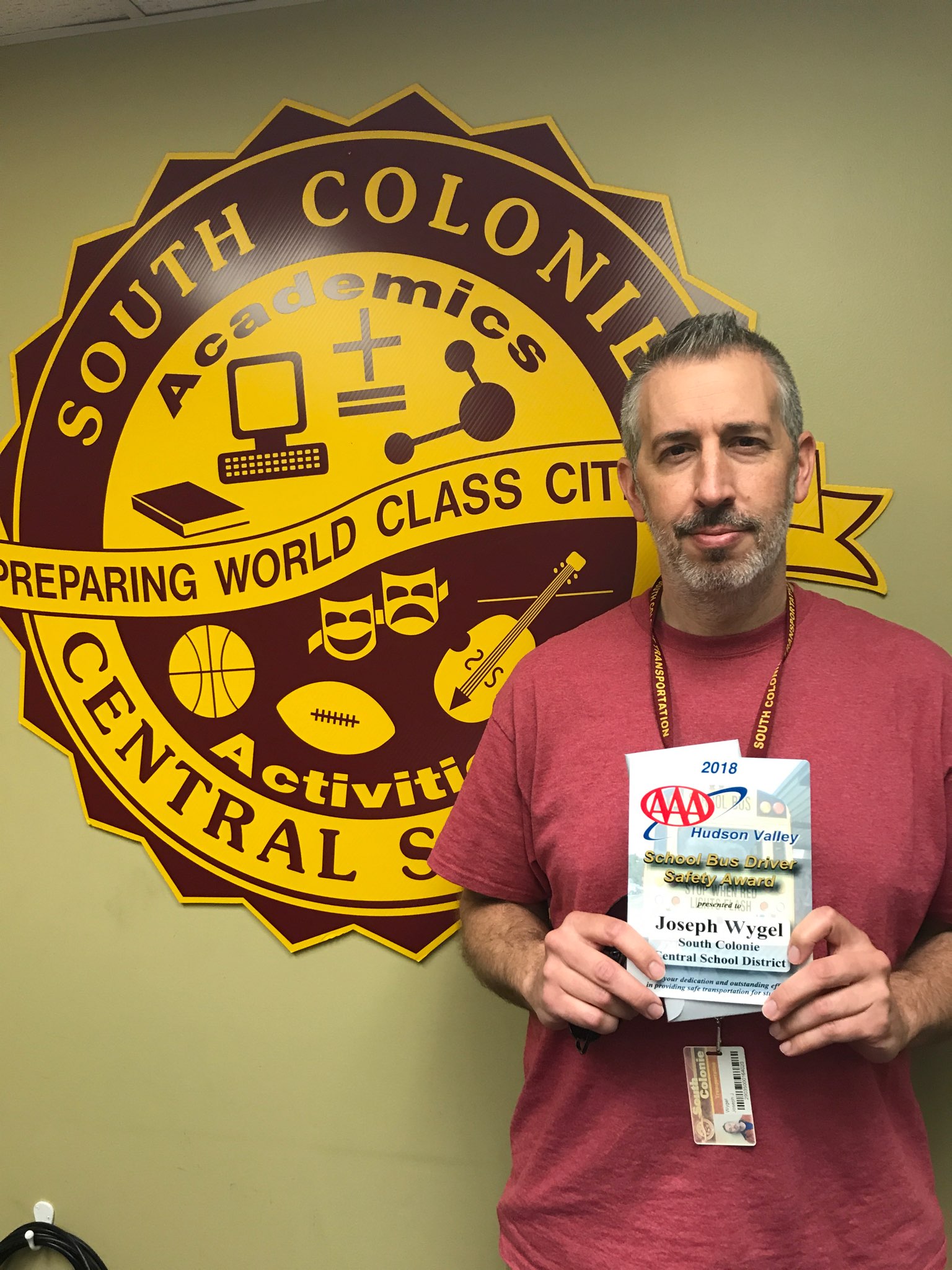 bus driver holds his award plaque