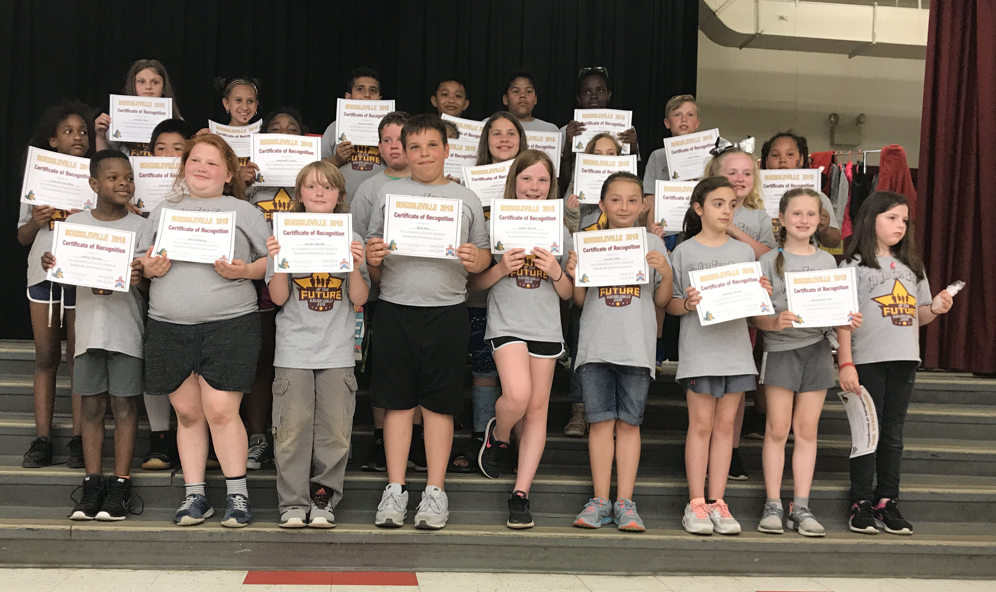 students stand with their award certificates