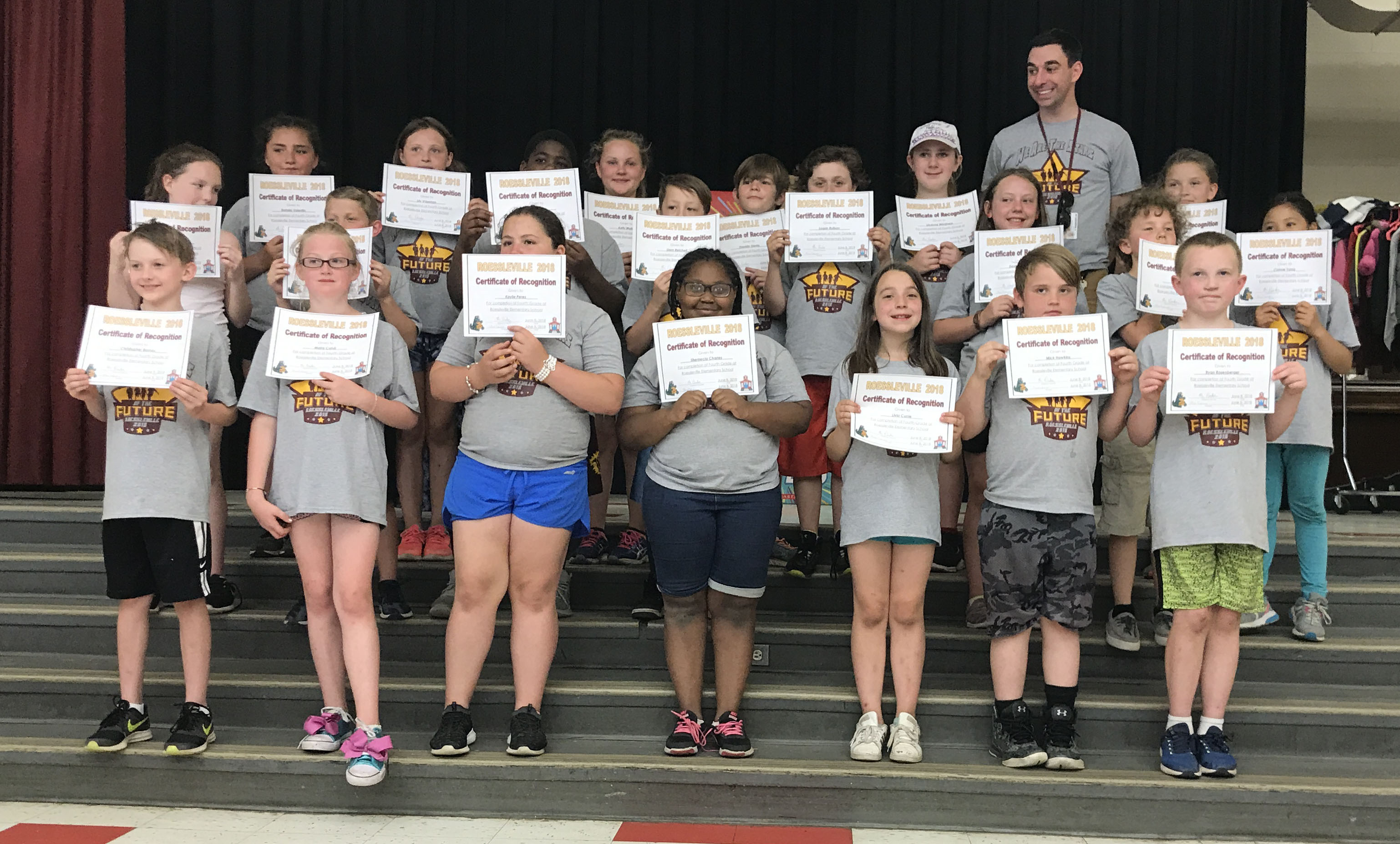 students stand with their award certificates