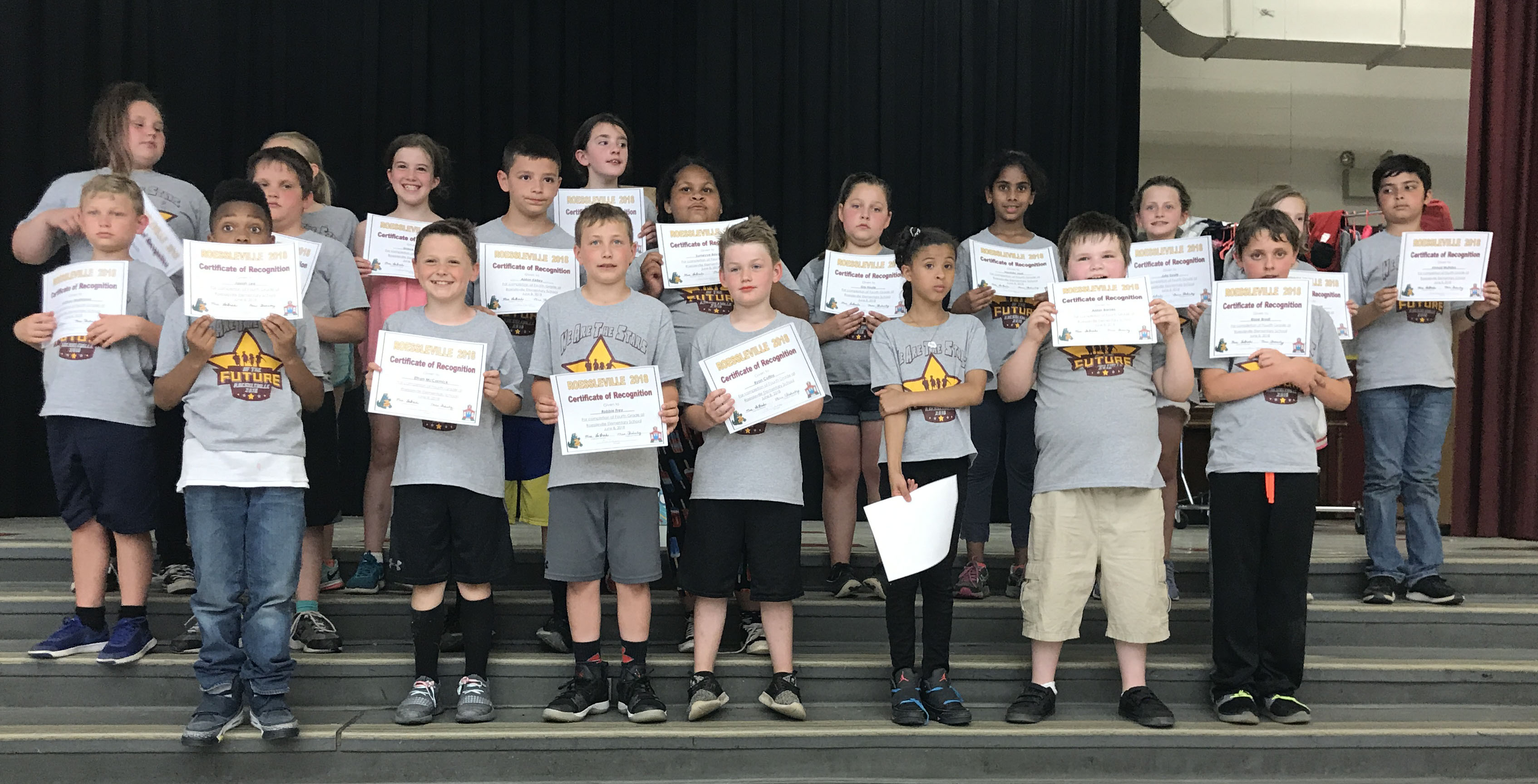 students stand with their award certificates