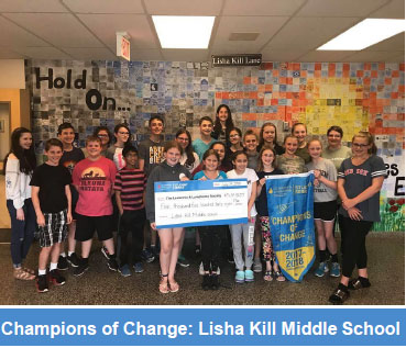 group of middle school students holding a large check