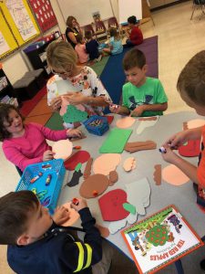 kids work on project together at a table