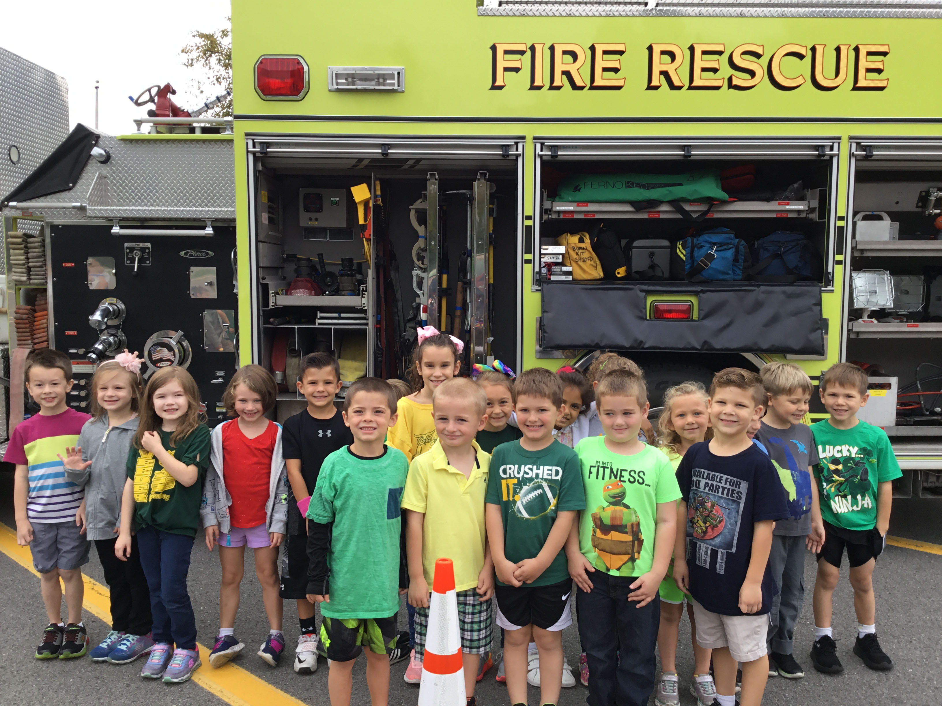 group of kindergartners stand in front of fire truck