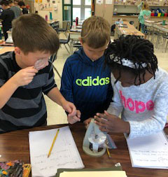 three children work on science together