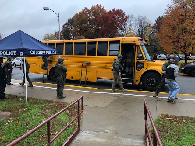 police conduct a safety drill outside a yellow school bus